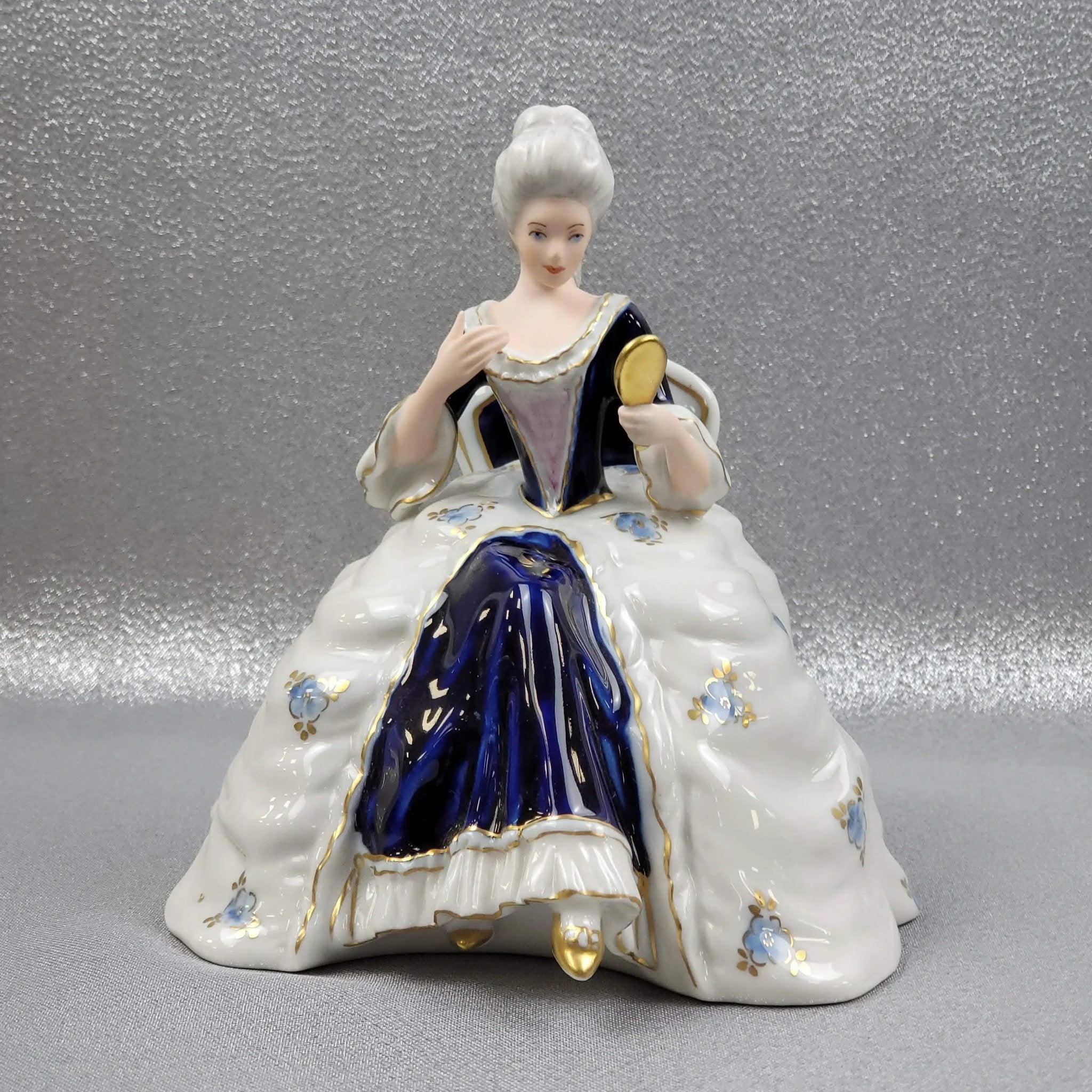 A porcelain figurine of a seated Rococo lady, 20th century, Italy. -  Bukowskis